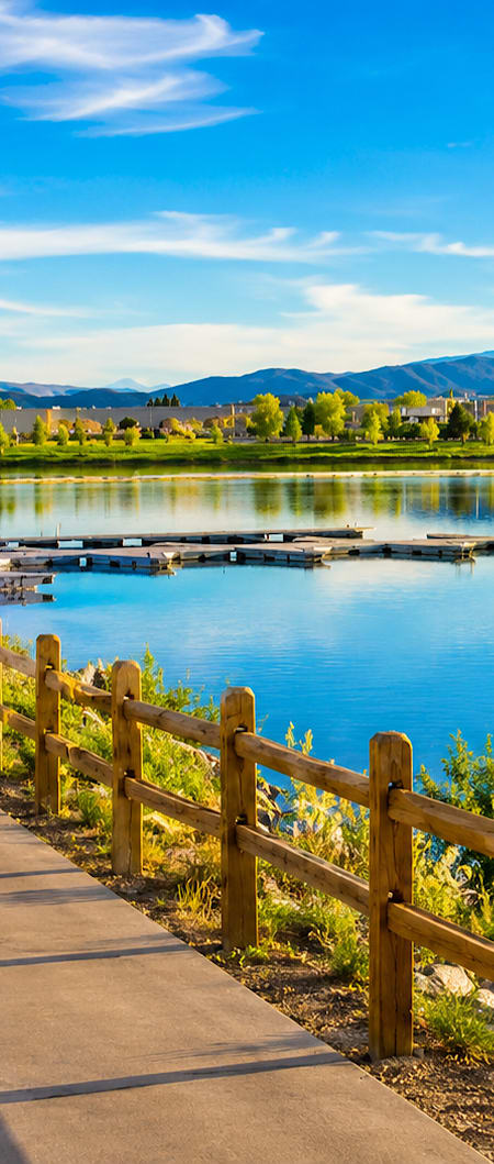 A person riding a bicycle on a path next to a lake.