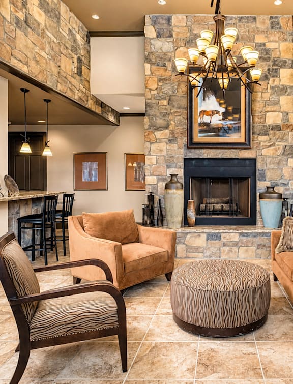 A living room with a stone fireplace and a painting above it.