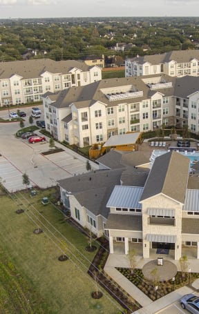 an aerial view of a large apartment complex with cars parked in front of it