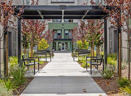a walkway with benches and a building in the background