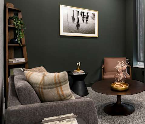 A living room with a grey couch, a brown chair, and a coffee table.