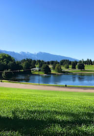 A golf course with a winding road in the foreground.