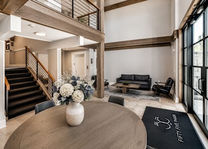 A modern living room with a staircase and a dining table.