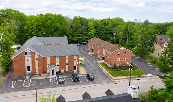arial view of a red brick building with trees in the background