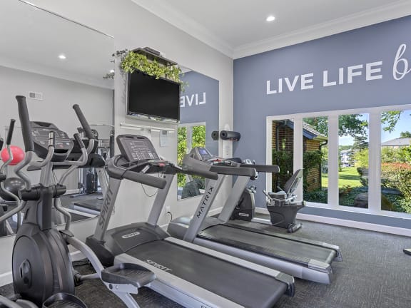 an indoor gym with treadmills and a tv at Weaver Farm, Florence, 41042