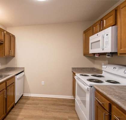 A kitchen with wooden cabinets and a white oven.