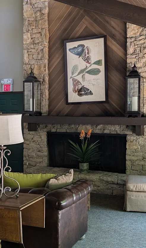 A living room with a fireplace and a painting above it.