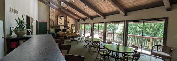 A dining area with tables and chairs and a bar area.
