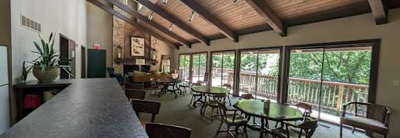 A dining area with tables and chairs and a bar area.