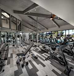 A gym with a variety of equipment including weights and treadmills.