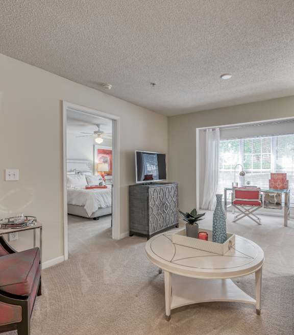 A living room with a red couch and a white coffee table.