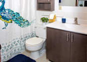 Thumbnail 23 of 46 - Bathroom with a peacock shower curtain at Countryside Estates Apartments, Plymouth, Minnesota
