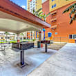 A wooden deck with lounge chairs and umbrellas in front of a building.