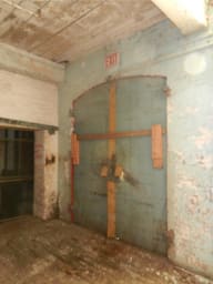Converse Mill Lofts before conversion, with wooden supports against a teal wall during construction.