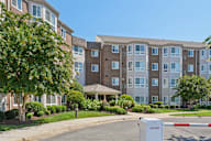 Apartment complex with a red and white barrier in front.