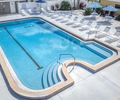a swimming pool at a hotel with lounge chairs