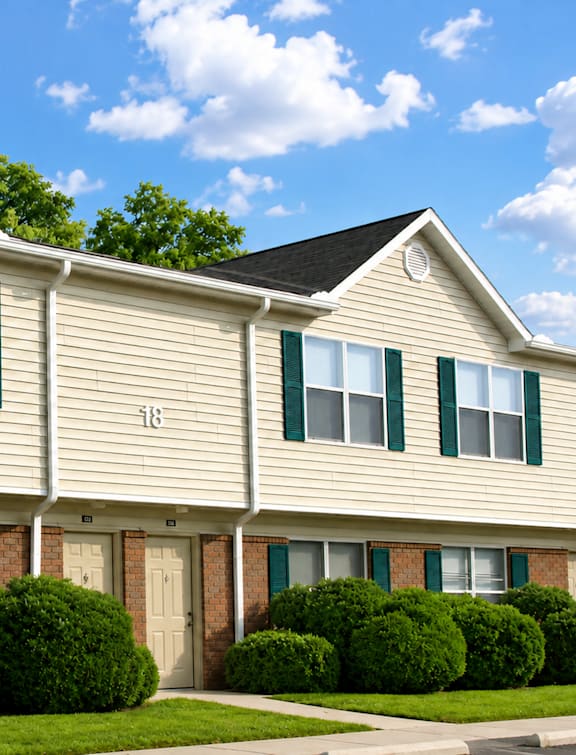 A row of houses with green shutters and a number 118 on the front.