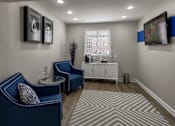 Thumbnail 19 of 40 - Waiting room with blue upholstered chairs and tv at The Brook At Columbia Apartments, Maryland, 21044