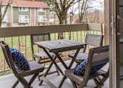 Thumbnail 16 of 40 - Private balcony with folding table and chairs at The Brook At Columbia Apartments, Columbia