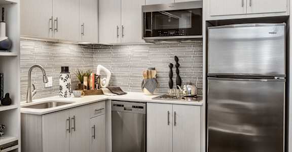 a kitchen with white cabinets and a stainless steel refrigerator