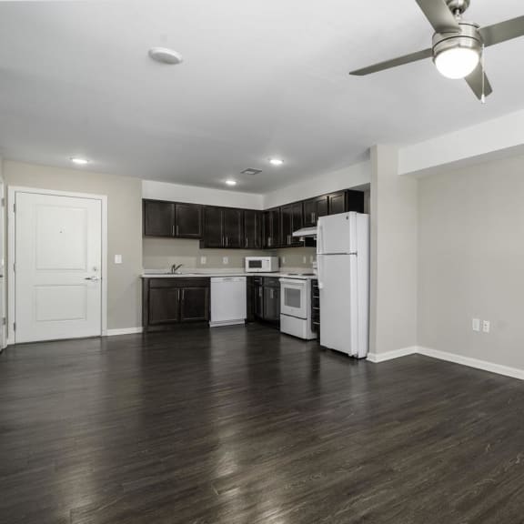 a renovated living room and kitchen with a ceiling fan