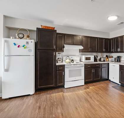 a kitchen with dark wood cabinets and white appliances