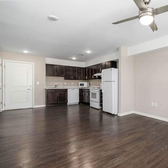 a renovated living room and kitchen with a ceiling fan