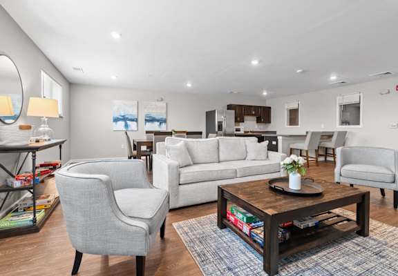 a living room with white couches and chairs