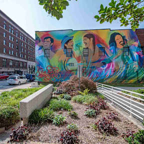 A mural of a man and woman is painted on the side of a building.