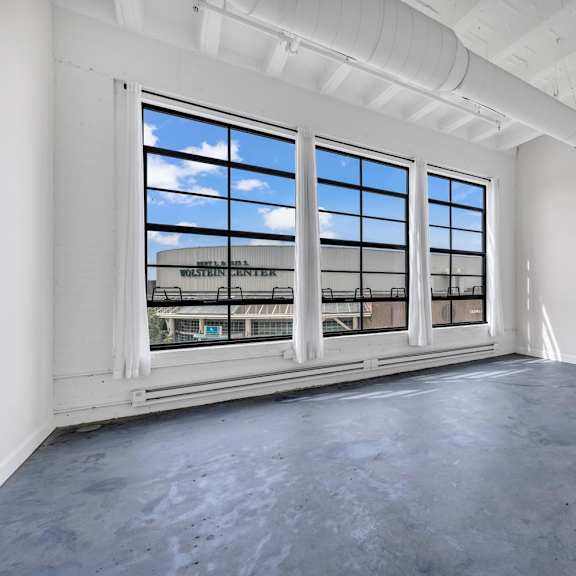 an empty room with large windows and a view of a train station