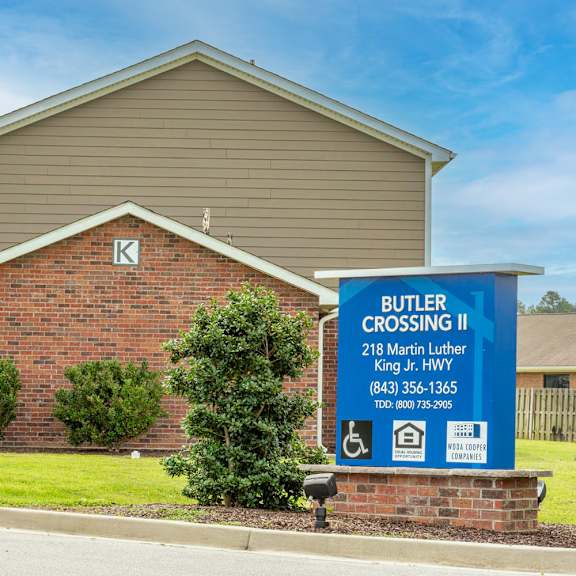 a sign in front of a brick house that says butter crossing ii
