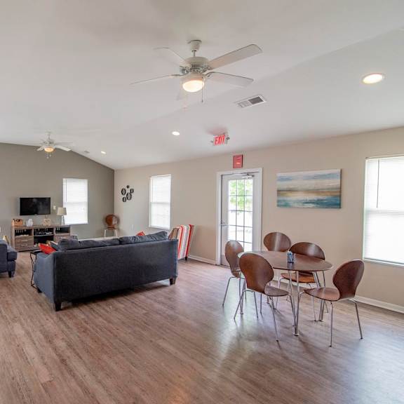 a living room with couches and a table with chairs