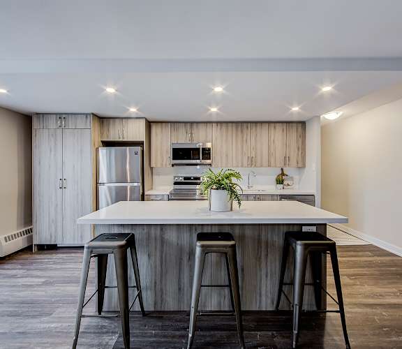 a kitchen with a large island with three stools in front of it