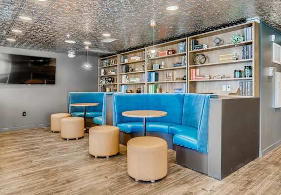 A room with a blue couch and a shelf with various items on it.