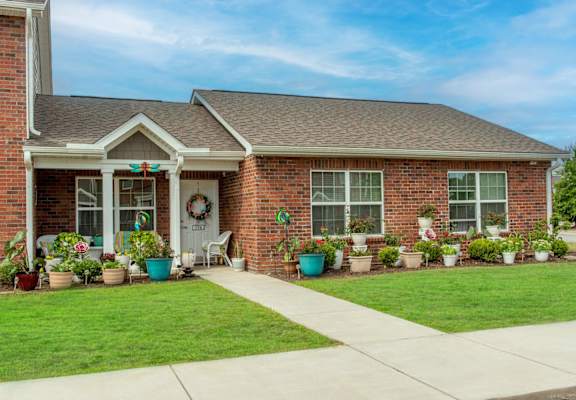 a house with a lawn and potted plants in front of it
