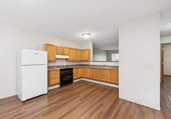 A kitchen with wooden cabinets and a white refrigerator.