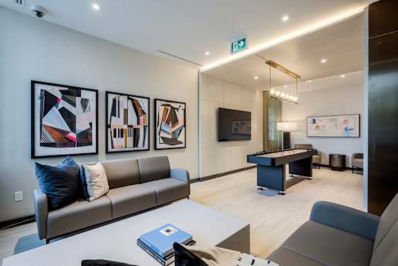 A modern living room with a grey couch, a coffee table, and a TV.