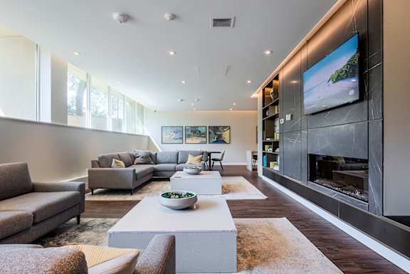 A modern living room with a grey sofa set, a coffee table, and a fireplace.