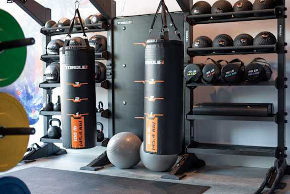 A gym with a punching bag and weights.