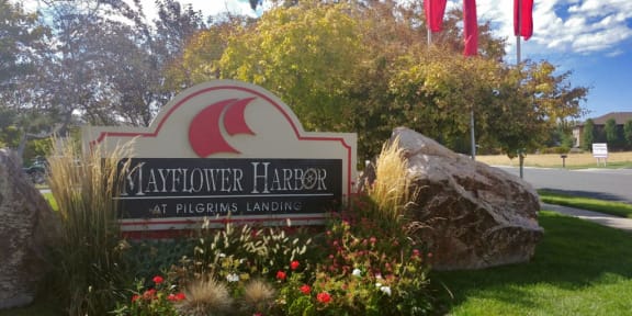 Property entrance sign with rocks and flowers