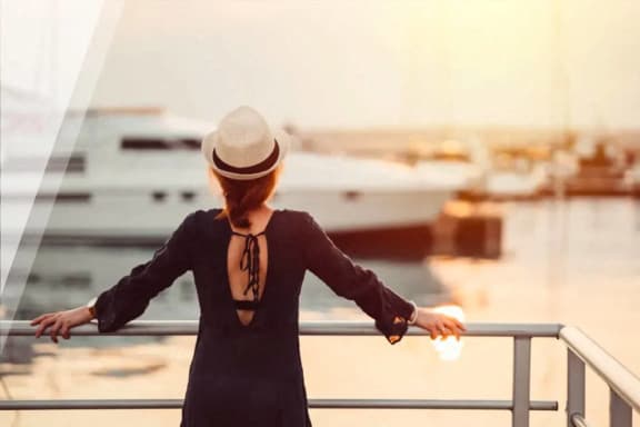 a woman in a hat overlooking a marina with boats