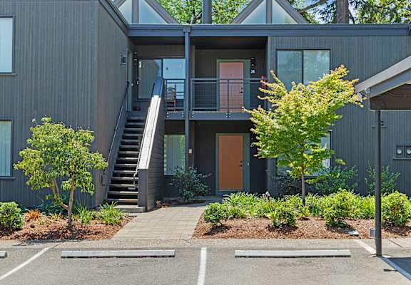 A modern house with a grey exterior and a wooden door.
