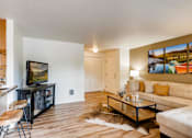 Thumbnail 3 of 34 - Apartments Near Happy Valley, OR For Rent - Spacious Living Area With Wood-Inspired Flooring, Plenty Of Windows To Let In Natural Sunlight, Front Door, And View Of Kitchen And Dining Area