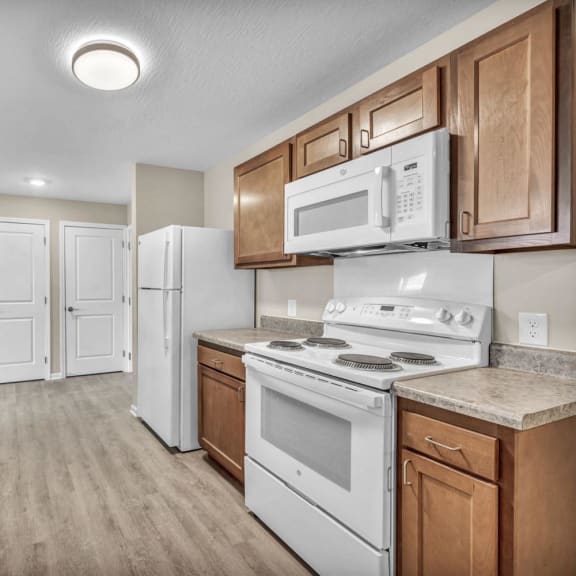 a kitchen with white appliances and wooden cabinets