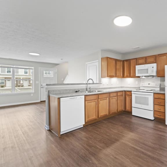 an empty kitchen with wooden cabinets and white appliances