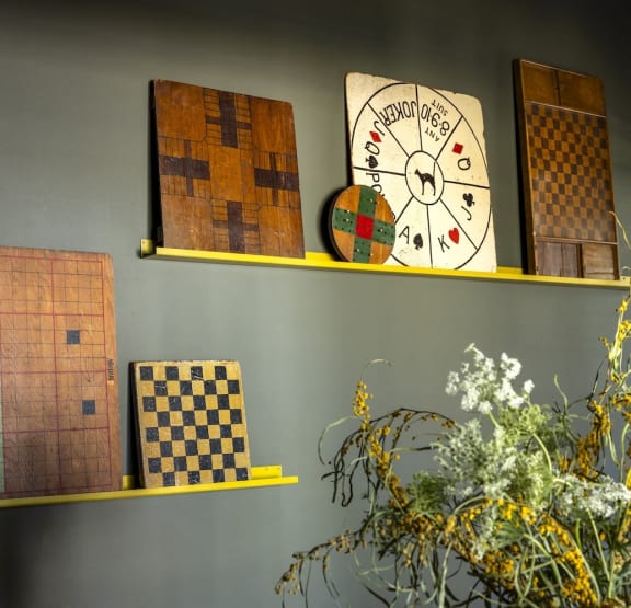 a shelf with a clock and chess boards on it