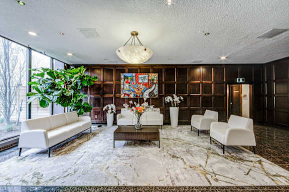 A living room with a large rug and a painting on the wall.
