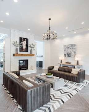 A modern living room with a fireplace and a striped rug.