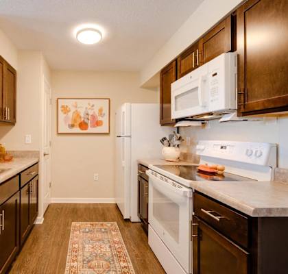 a kitchen with white appliances and wooden cabinets