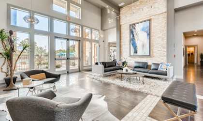 a living room with couches and chairs and a wall of windows